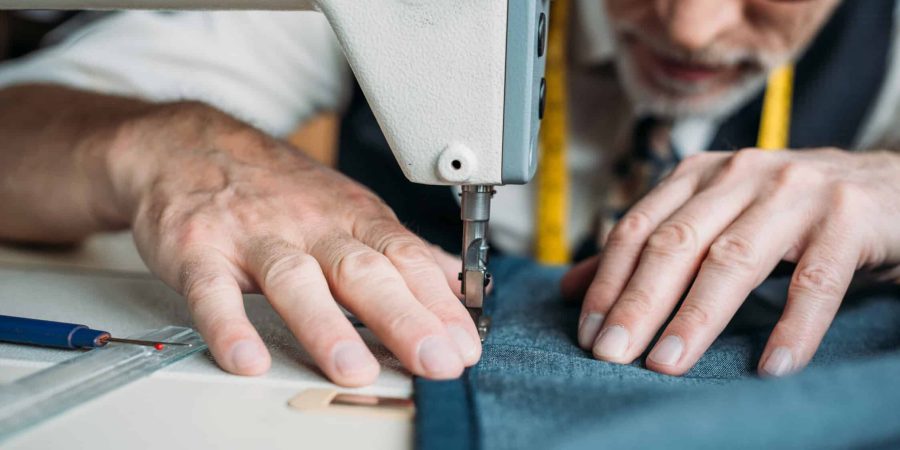cropped image of dressmaker sewing cloth with sewing machine at sewing workshop